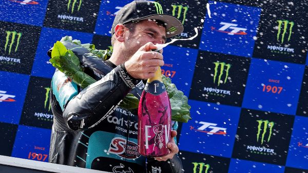 Michael Dunlop celebrating on the Winners Podium with a spray of champagne at the 2025 TT Supersport Race 1.